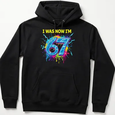 Colorful splatter design t-shirt with the text I WAS NOW I'M 67 — printed on a unisex hoodie
