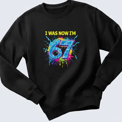 Colorful splatter design t-shirt with the text I WAS NOW I'M 67 — printed on a sweatshirt