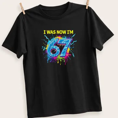 Colorful splatter design t-shirt with the text I WAS NOW I'M 67