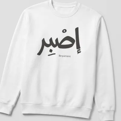 Arabic calligraphy design reading Sabr Be patient in black and white — printed on a unisex sweatshirt