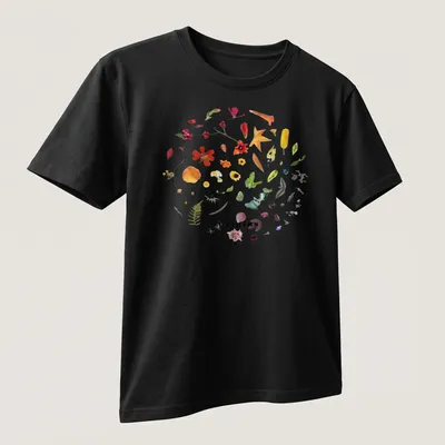 Botanical circle wreath design with colorful wildflowers and the word 'origins' — printed on a unisex t-shirt (angled view)