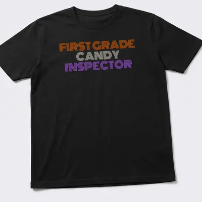 Bold striped Halloween tee featuring First Grade Candy Inspector text