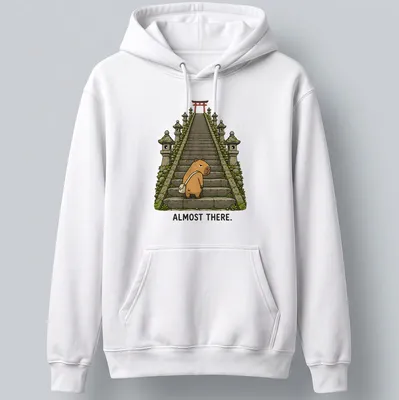 Kawaii capybara illustration climbing stairs with text 'ALMOST THERE.' — printed on a unisex hoodie