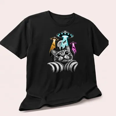 Black and white illustration of a cat taking a selfie with colorful UFOs. — printed on a unisex t-shirt (angled view)