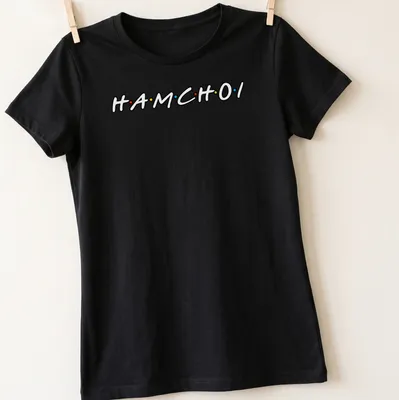 Playful typography shirt featuring colorful text 'HAM CHOI' in black, red, yellow, and blue. — printed on a women's shirt