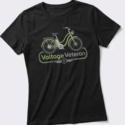 Modern illustrated E-bike graphic with text 'Voltage Veteran' in green and gray — printed on a women's shirt