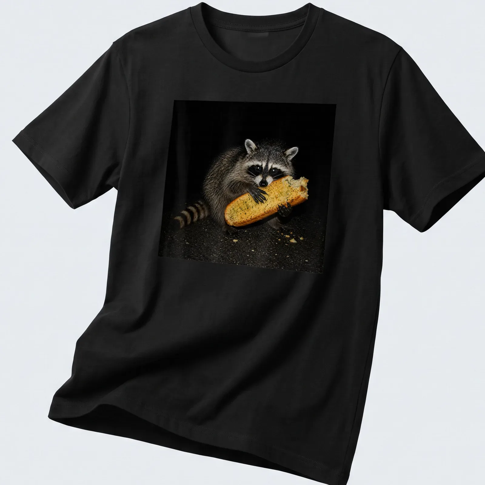 Realistic image of a feral raccoon eating garlic bread, captured in a humorous moment — printed on a unisex t-shirt