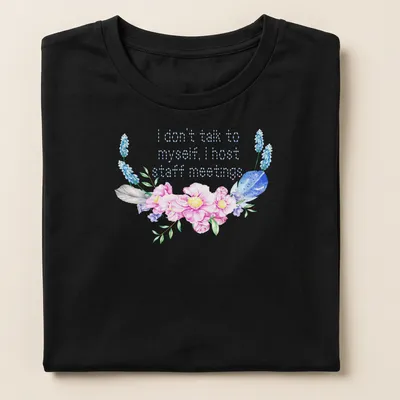 Floral design with humorous text about hosting staff meetings. — printed on a women's shirt