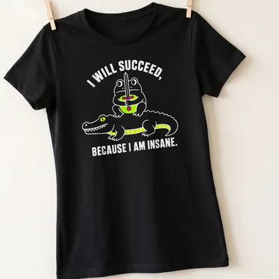 Cartoon frog and crocodile with the text 'I WILL SUCCEED, BECAUSE I AM INSANE.' in bright colors — printed on a women's shirt