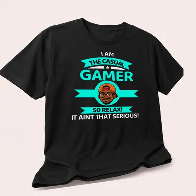 Cartoon design with text 'THE CASUAL GAMER SO RELAX!' in turquoise, black, orange, and white colors. — printed on a unisex t-shirt (angled view)