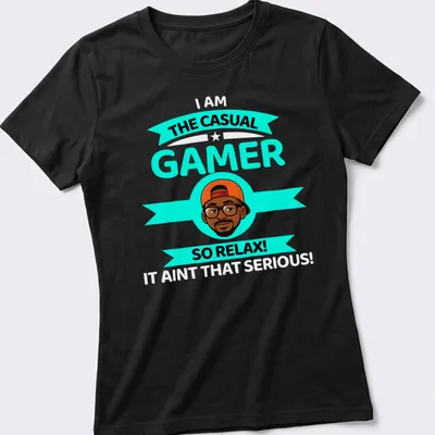 Cartoon design with text 'THE CASUAL GAMER SO RELAX!' in turquoise, black, orange, and white colors. — printed on a women's shirt