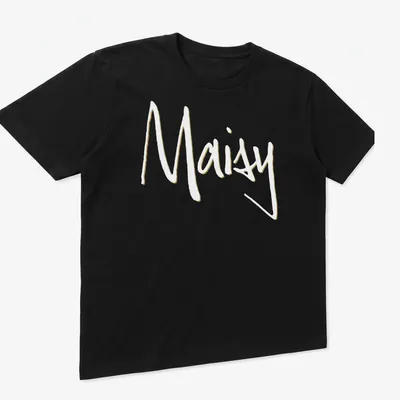 Handwritten Maisy personalized t-shirt in beige and white colors. — printed on a unisex t-shirt (angled view)