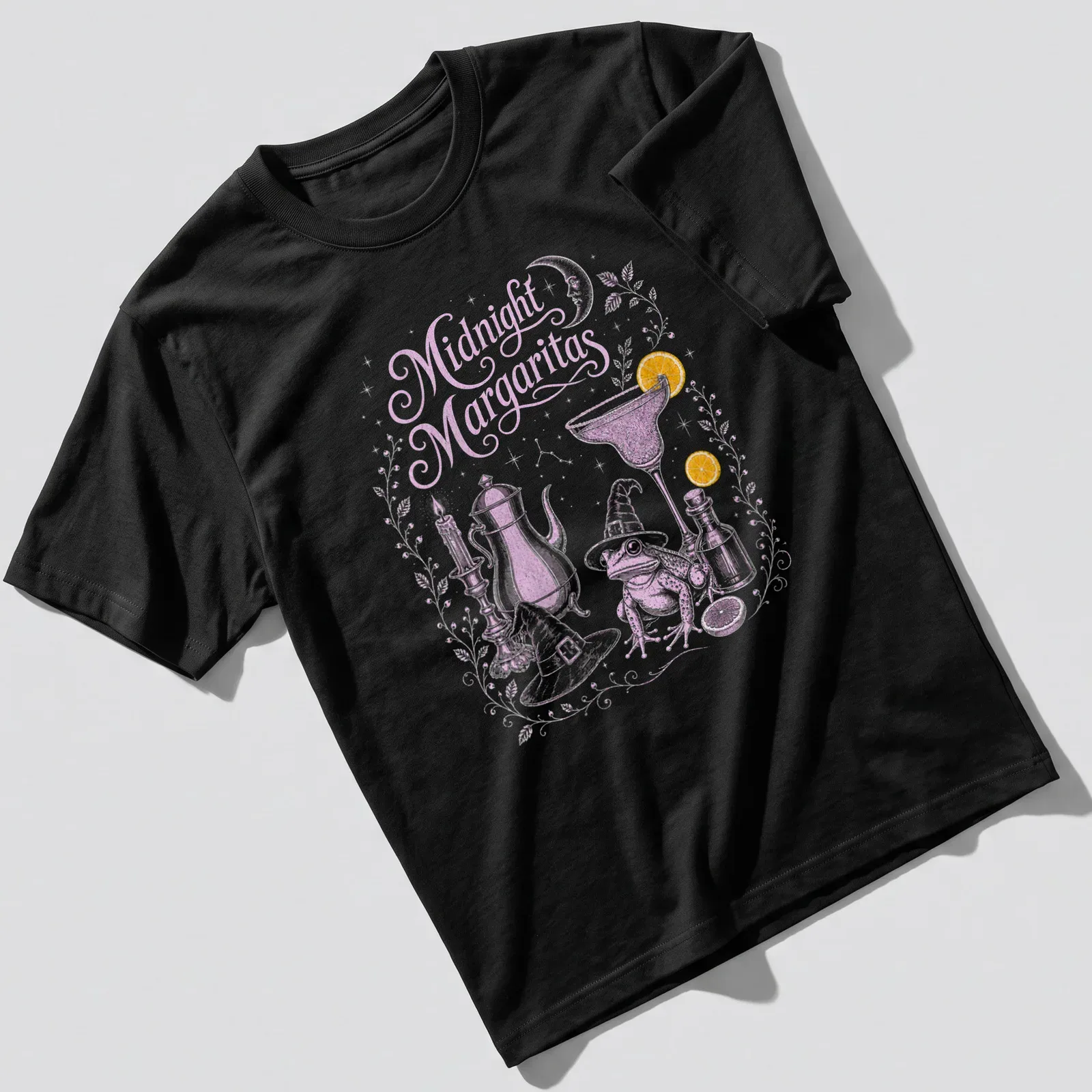 Whimsical illustration of a frog in a witch hat holding a margarita with candles around it — printed on a unisex t-shirt