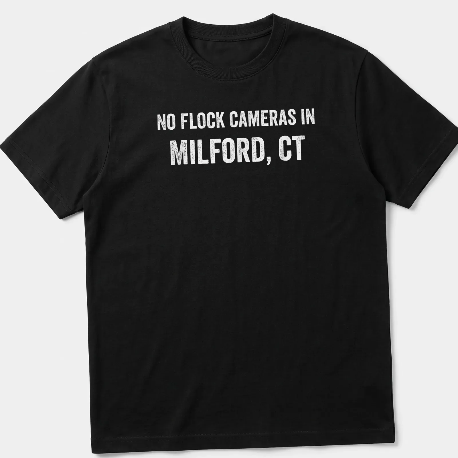 Bold text graphic stating No Flock Cameras in Milford, CT on a grey background — printed on a unisex t-shirt