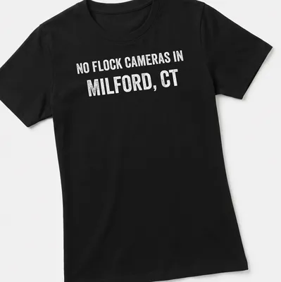 Bold text graphic stating No Flock Cameras in Milford, CT on a grey background — printed on a women's shirt