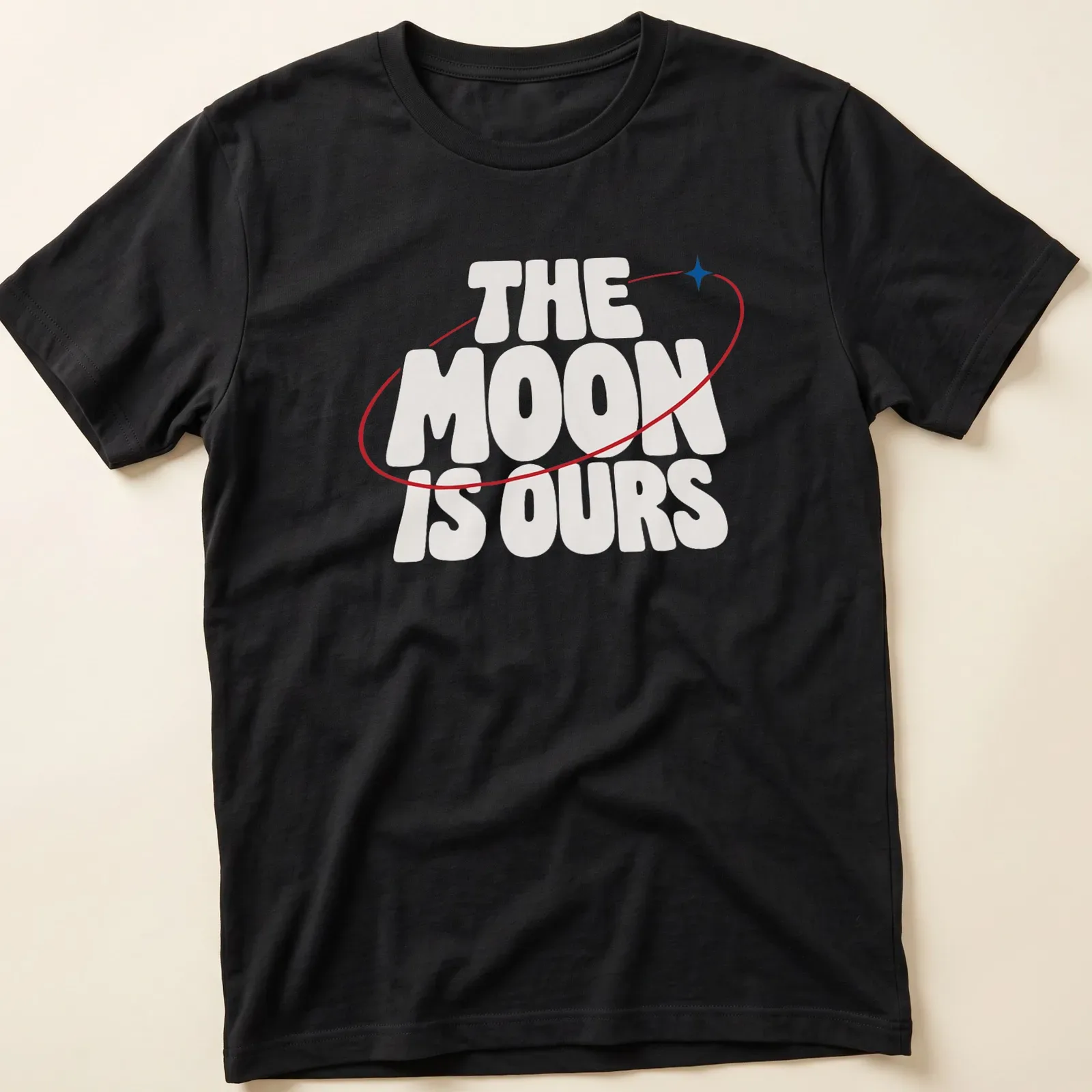 Bold typography T-shirt featuring the phrase 'THE MOON IS OURS' alongside a moon graphic — printed on a unisex t-shirt