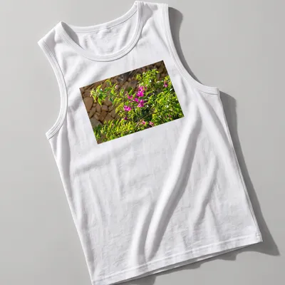 Natural photography of pink bougainvillea blossoms against a stone wall — printed on a tank top