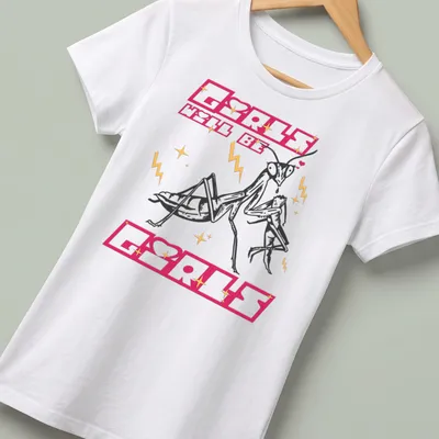 Bold cartoon design of a praying mantis with text 'Girls Will Be Girls' in pink and gold — printed on a women's shirt