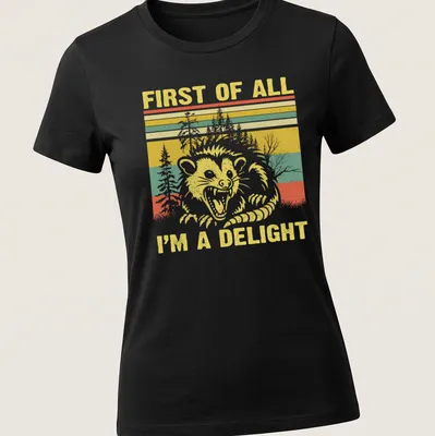Vintage retro T-shirt featuring a raccoon with the text 'FIRST OF ALL I'M A DELIGHT' — printed on a women's shirt
