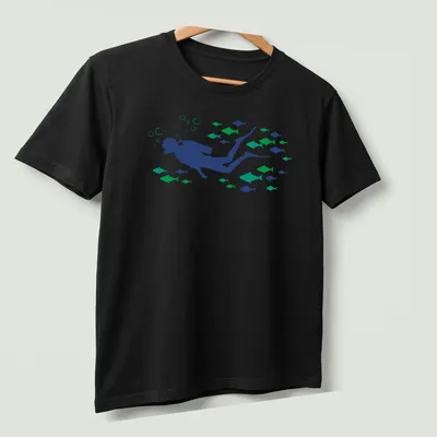 Woodcut style graphic of a scuba diver swimming with fish in blue and green tones — printed on a unisex t-shirt (angled view)