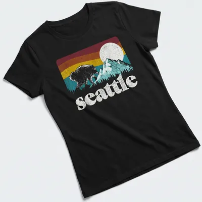 Retro bear graphic with Seattle text in pink, blue, yellow, and green — printed on a women's shirt