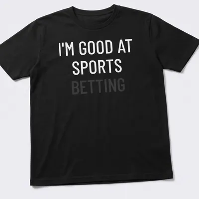 Bold typography t-shirt saying 'I'm Good At Sports Betting' in black on white.