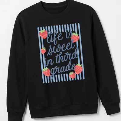 Playful illustration of a strawberry with text 'life is sweet in third grade' — printed on a unisex sweatshirt