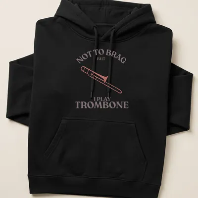 Illustration of a trombone with text: Not to Brag But I Play Trombone in pink, brown, and white — printed on a unisex hoodie