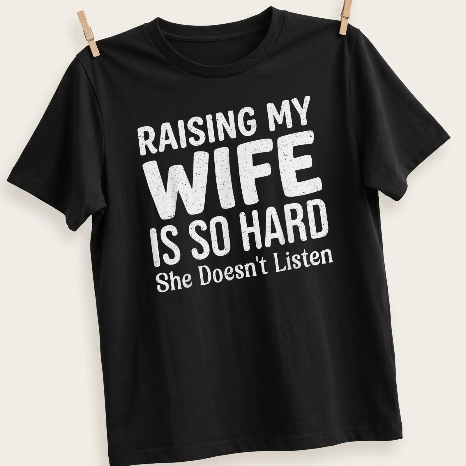 Bold playful typography on a light gray shirt about raising a wife. — printed on a unisex t-shirt