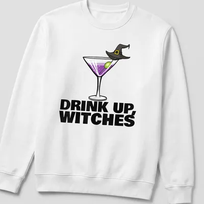 Cartoon design of a cocktail drink with the text Drink Up, Witches in purple and green — printed on a unisex sweatshirt