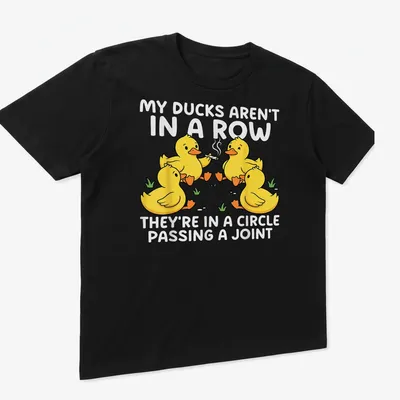 Cartoon design featuring yellow ducks in a circle passing a joint with humorous text — printed on a unisex t-shirt (angled view)